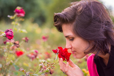 Close-up portrait of woman with red flowers