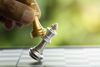 Close-up of human hand holding chess piece