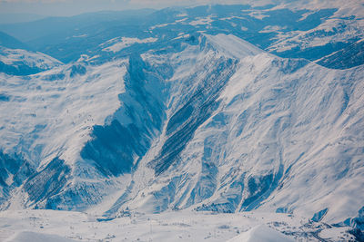 Aerial view of snow covered mountain range against sky