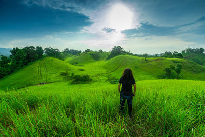 Rear view of man on field against sky