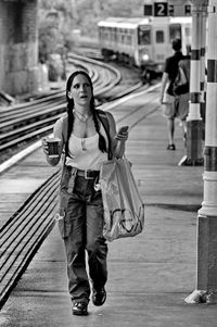 Portrait of woman with umbrella standing in city