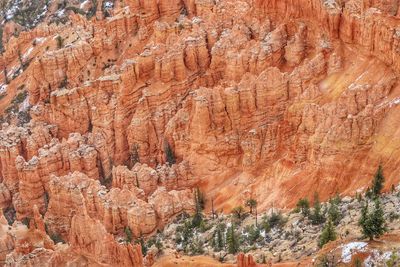 High angle landscape of a snow dappled valley of orange rock spires and hoodoos