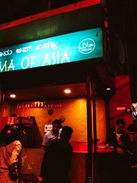 People photographing illuminated smart phone at night