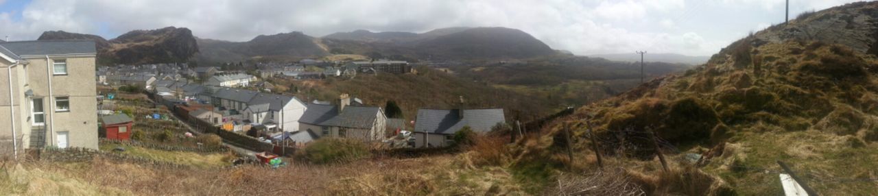 mountain, building exterior, landscape, architecture, built structure, house, sky, mountain range, panoramic, residential structure, village, field, cloud - sky, day, nature, town, grass, high angle view, residential building, outdoors