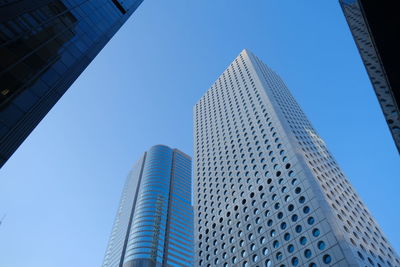 Low angle view of modern buildings against clear blue sky
