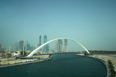 View of bridge and cityscape against clear sky