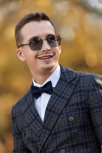 Portrait of young man wearing sunglasses standing outdoors
