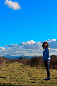 Woman standing on field against sky