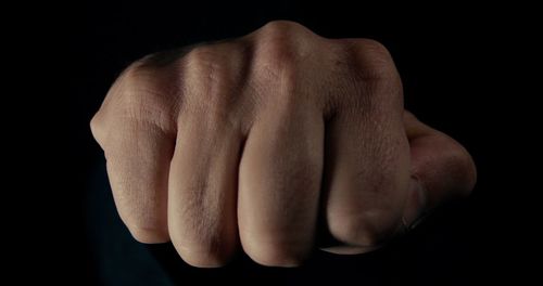 Close-up of human hand against black background