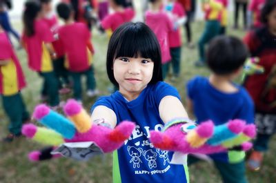 Portrait of smiling girl wearing multi colored gloves