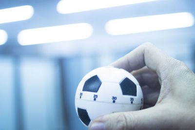 Close-up of hand holding ball at home