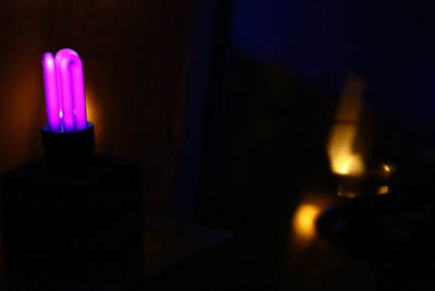 Close-up of lit candle in the dark