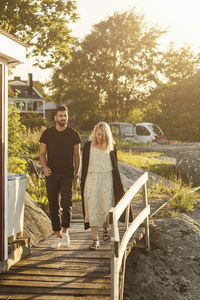 Full length of young friends walking on boardwalk