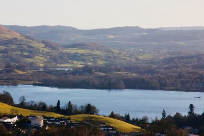 Scenic view of river and mountains against sky