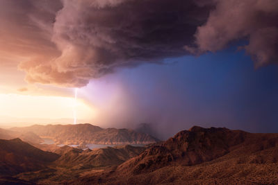 A powerful monsoon thunderstorm drifts across lake mead at sunset.