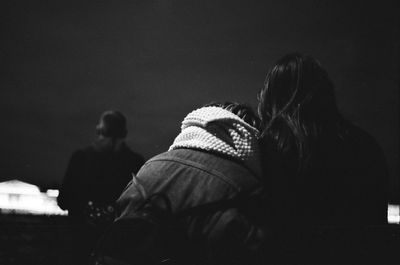 Rear view of women sitting outdoors at night