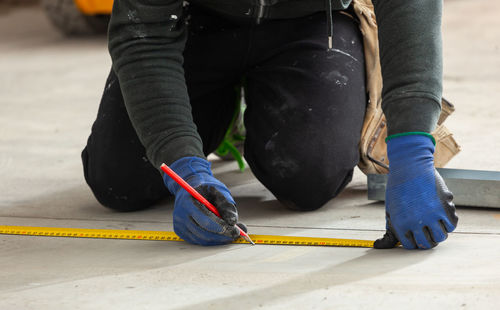 Low section of carpenter working on tiled floor