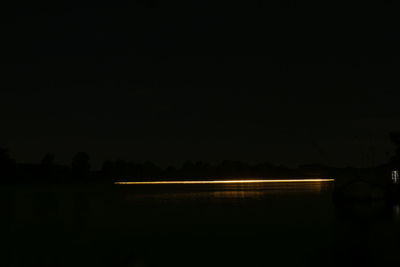 Scenic view of lake against sky at night