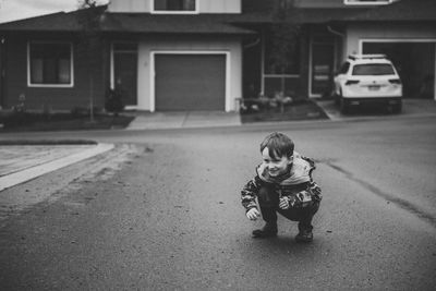 Full length of girl with umbrella on street in city