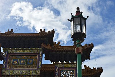 Low angle view of temple and street light against sky