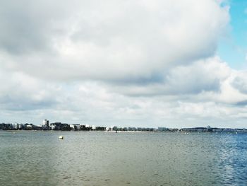 Scenic view of sea by buildings against sky