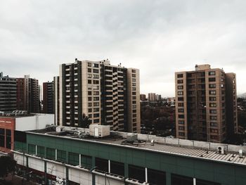 Buildings in city against cloudy sky