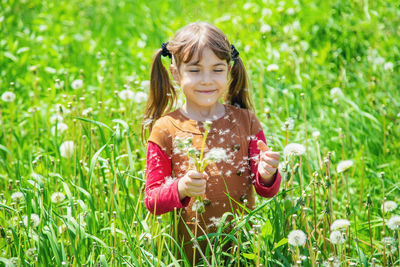 Smiling girl holding dandelion seed