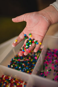 Unrecognizable child playing with colorful mosaic pieces while having fun at home