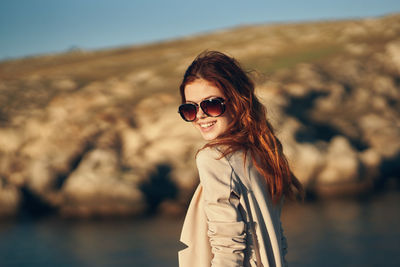 Portrait of woman wearing sunglasses standing outdoors