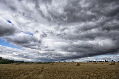 Scenic view of field against dramatic sky