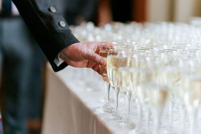 Midsection of man holding glass wedding reception