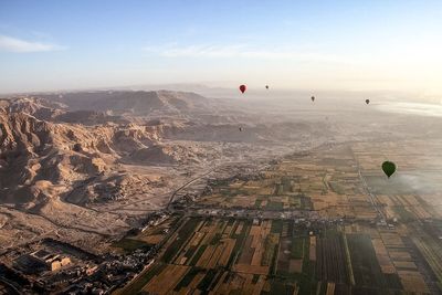 Hot air balloons flying over landscape