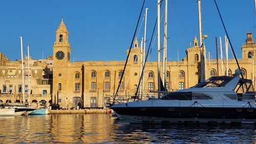 Sailboats moored in water against clear sky