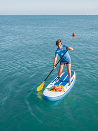 Handsome paddle boarder.sportsman paddling on stand up paddleboard.sup surfing. vacation on seaside.