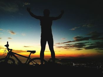 Silhouette man standing on beach against sky during sunset