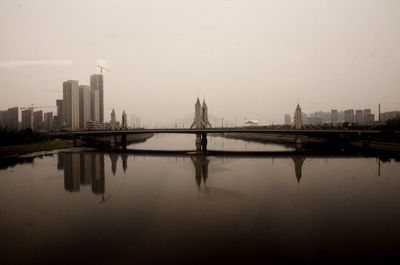 Reflection of city in river against sky