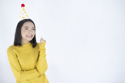 Portrait of a smiling young woman against white background