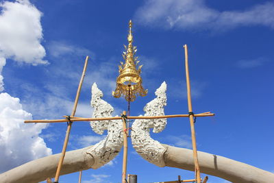 Low angle view of sculpture and building against sky