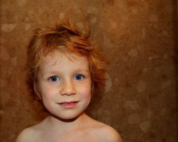 Portrait of a shaggy red-haired boy with gray eyes.boy with big eyes looks straight into the camera.