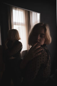 Young woman reflecting on mirror at home