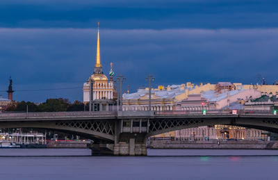 Bridge over river in city against sky