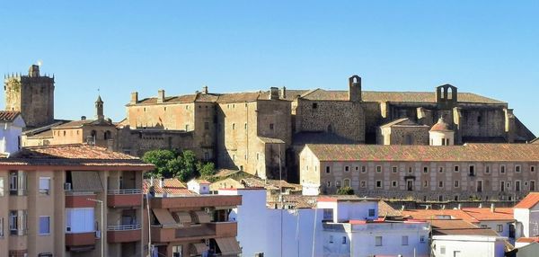 Old buildings in town against clear blue sky