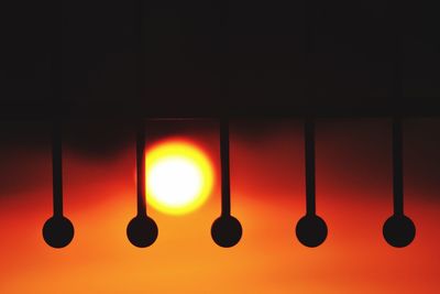 Close-up of illuminated lamp against orange sky