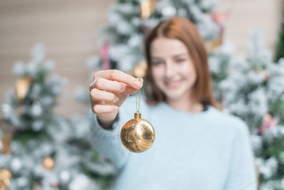 Portrait of young woman holding christmas decoration