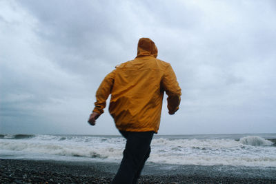 Rear view of person walking on beach