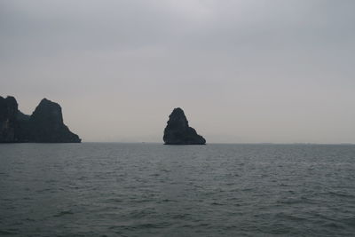 Scenic view of rocks in sea against sky