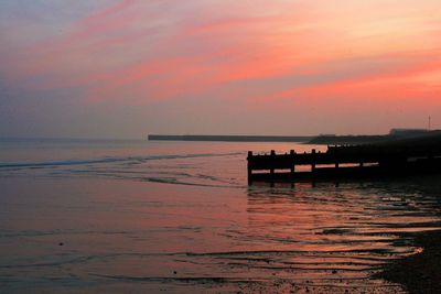 Pier on sea at sunset