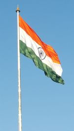 Low angle view of flag against clear blue sky