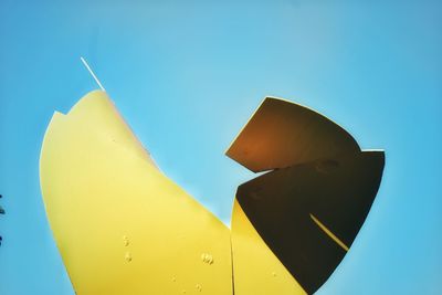 Low angle view of yellow toy against blue sky