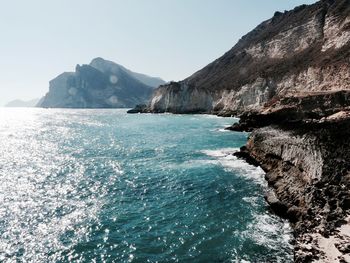 Scenic view of sea and mountains against clear sky